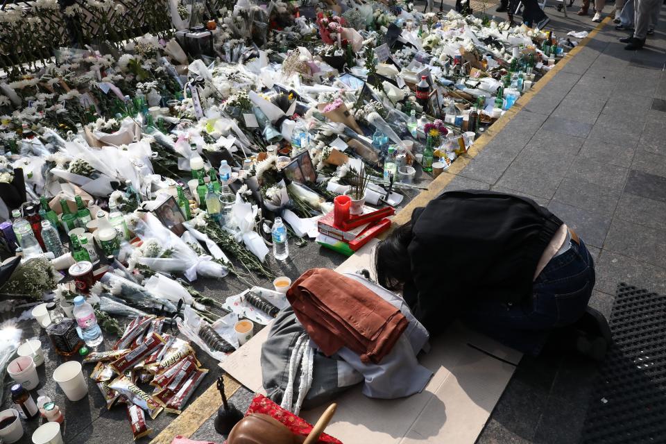 A woman pays tribute to the victims of the Halloween celebration stampede, on the street near the scene on 1 November 2022 in Seoul, South Korea (Getty Images)