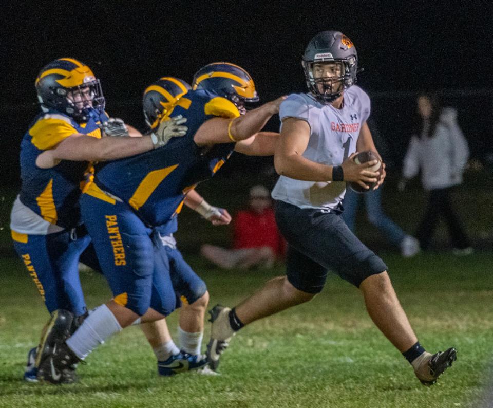 Gardner quarterback Alexavier Figueroa is chased by the Quabbin defense in the second quarter Thursday.