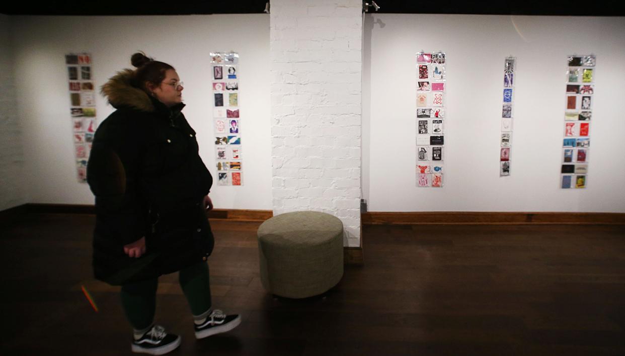 A visitor looks around the displayed postcard in a Postcard Exchange Exhibition at Iowa State University Memorial Union Building on Monday, Jan. 22, in Ames, Iowa.