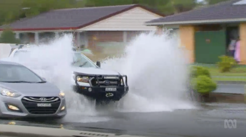 Cars drive through heavy rain in Ballina, NSW.