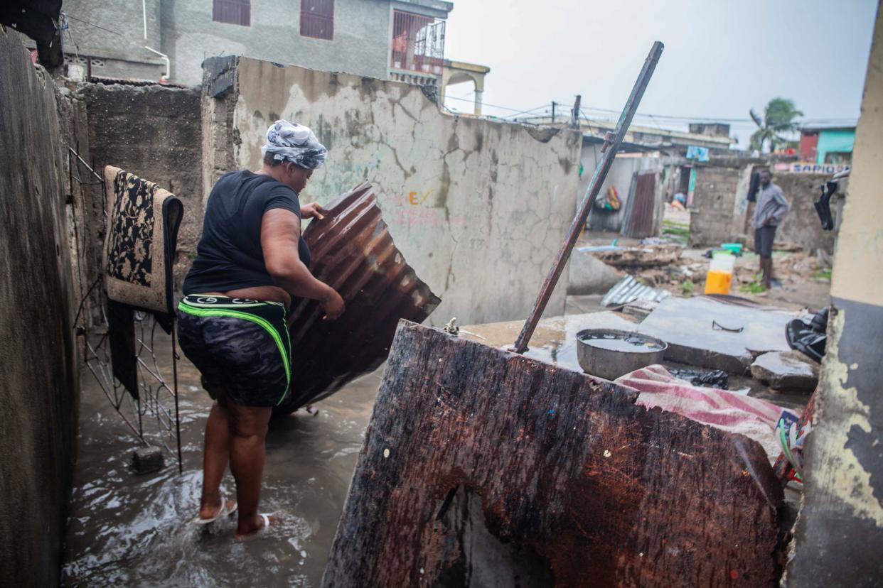 A woman cleans her house as she checks what can be recovered as heavy rain brought by tropical storm Grace hits Haitians just after a 7.2-magnitude earthquake struck Haiti on Aug. 17, 2021, in Les Cayes, Haiti.