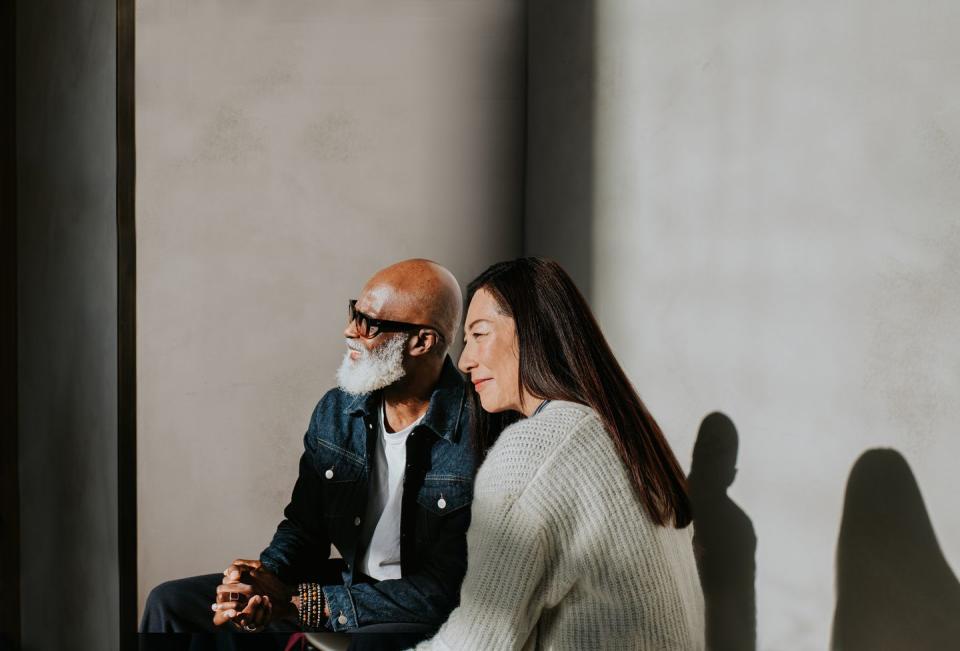 conceptual, simple image of a man and a woman sitting beside each other