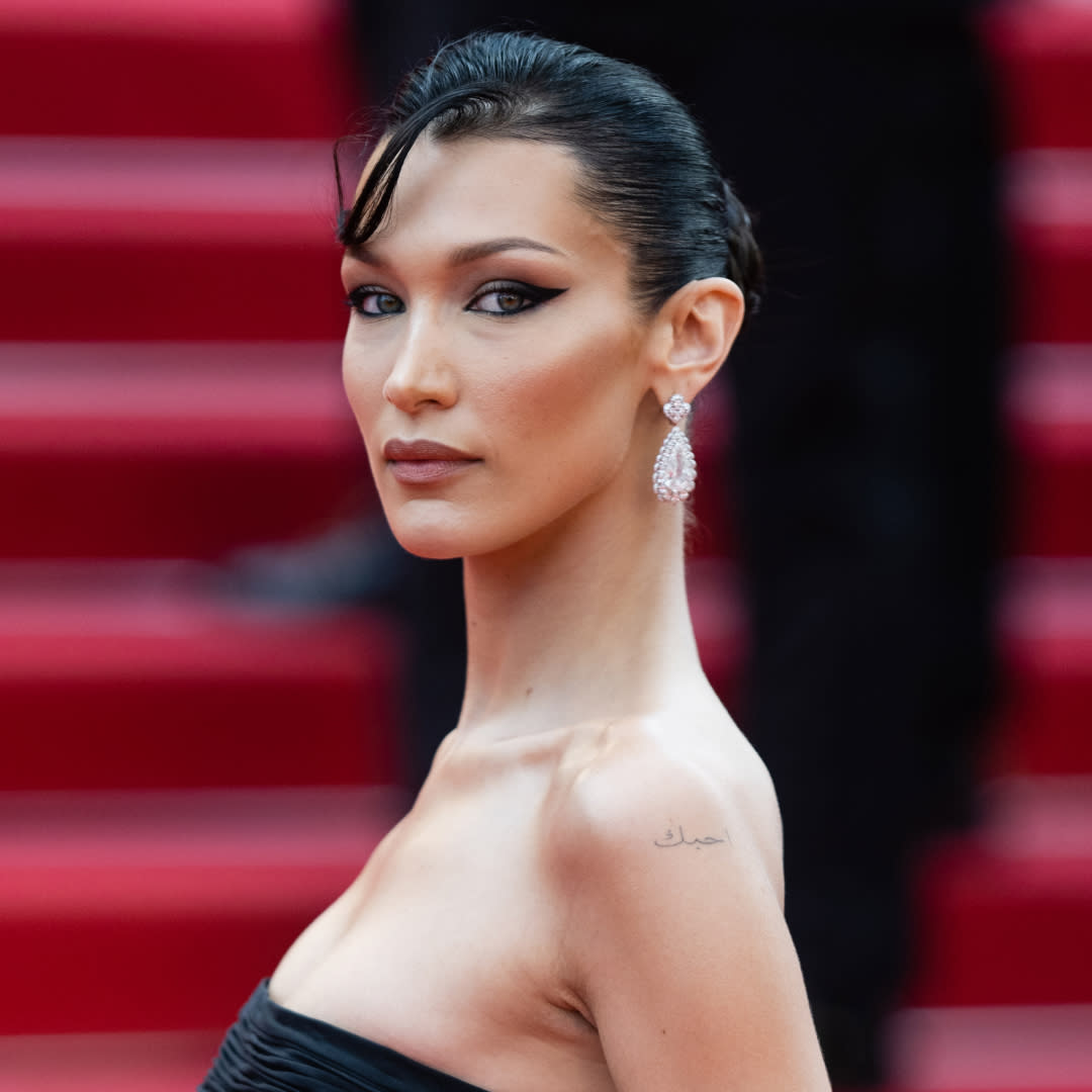  Bella Hadid wearing a low cut strapless dress on a red carpet to illustrate a story about her nearly naked Orebella dresses. 