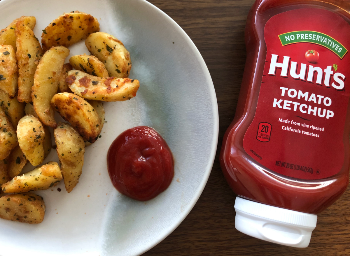 hunts ketchup bottle with ketchup and fries on a plate. 