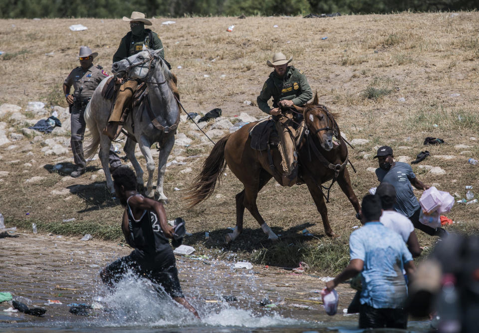 Mounted border agents attempt to contain migrants as they cross the Rio Grande from Mexico into Del Rio, Texas, on Sunday, September 19, 2021.  / Credit: Felix Marquez / AP