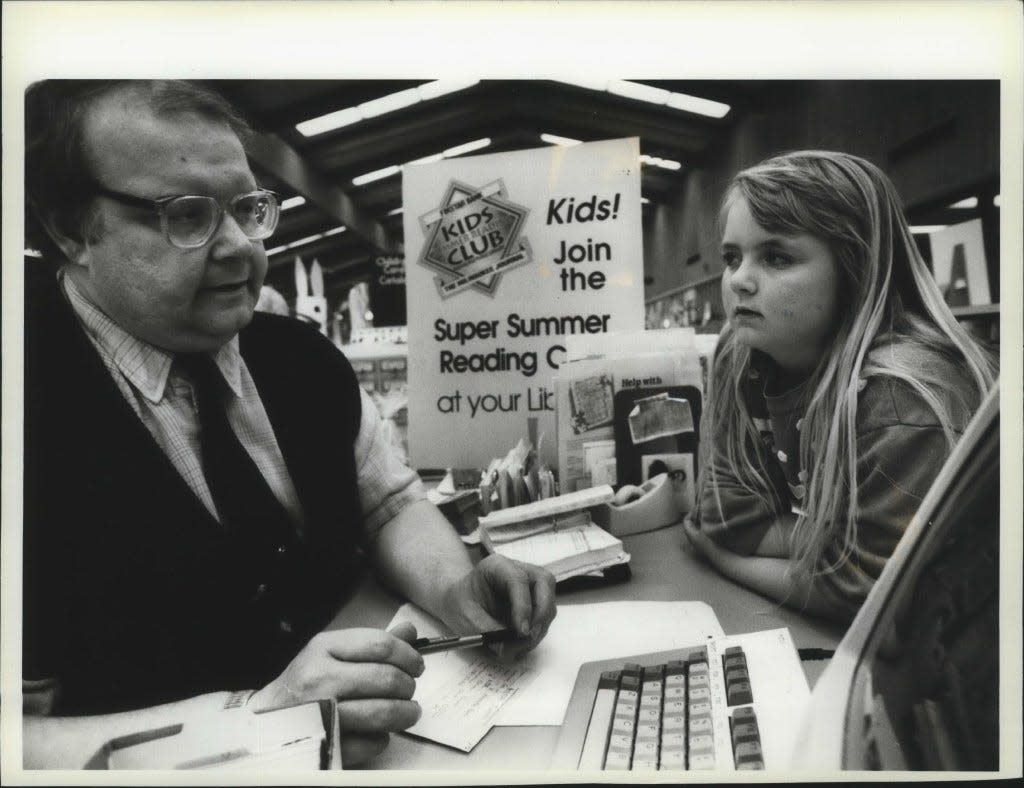 Third grader Amanda Foster listens as children's librarian Neil Kaluzny explains the Kids Summer Reading Club at the Tippecanoe Library in 1993. The club gives young readers a variety of incentives to reach their personal reading goals.