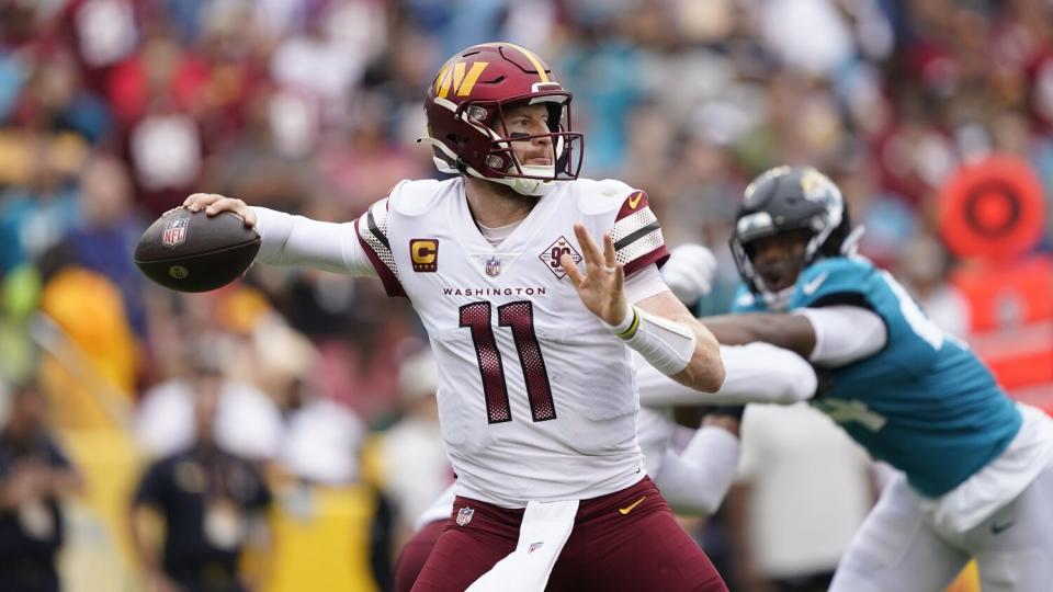 Washington Commanders quarterback Carson Wentz throws to a receiver.