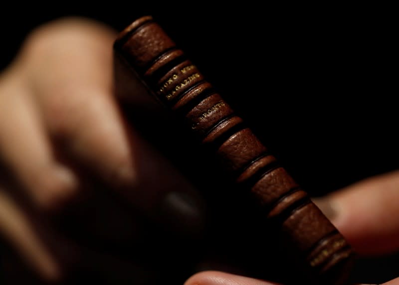 An employee displays the second issue of Young Men's Magazine, a miniature manuscript dated 1830, written by Charlotte Bronte when she was 14 years old, before being put on auction at Drouot auction house in Paris