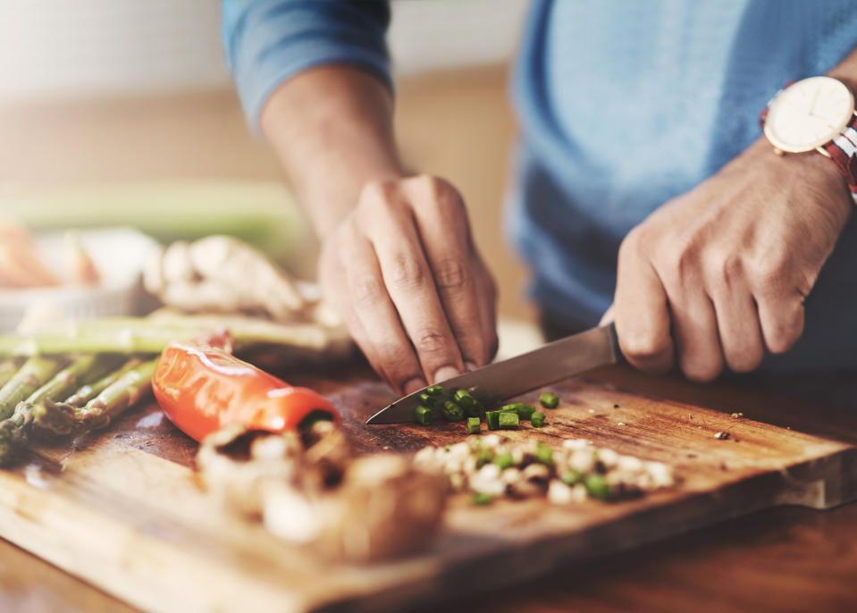 a man cutting vegetables on a cutting board