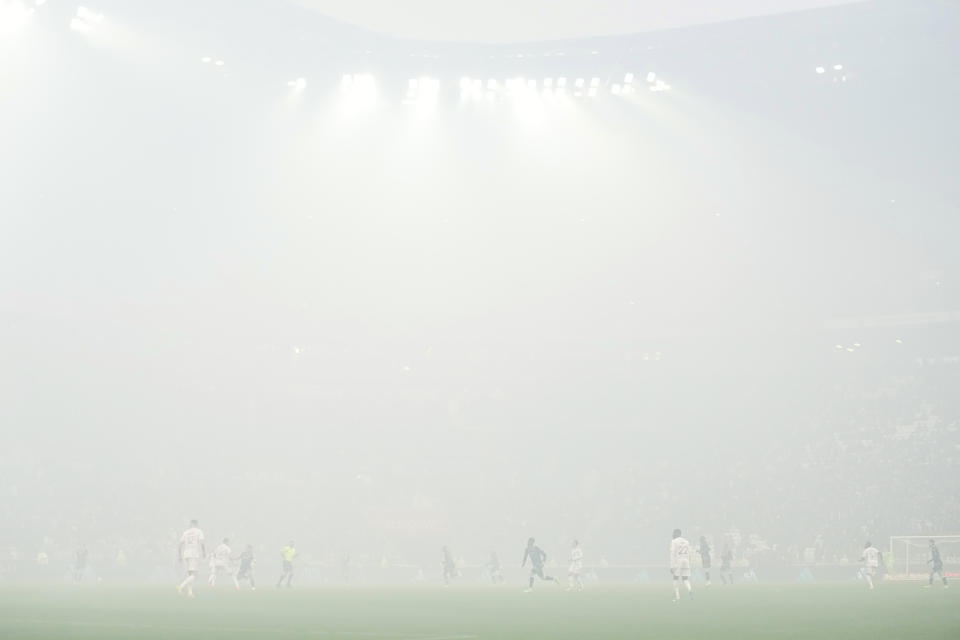 Smoke from pyrotechnics obscured the stadium as Monaco scored their side's first goal in the first few minutes during a French League One soccer match between Lyon and Monaco at the Groupama stadium in Decines, outside Lyon, France, Sunday, April 28, 2024. (AP Photo/Laurent Cipriani)