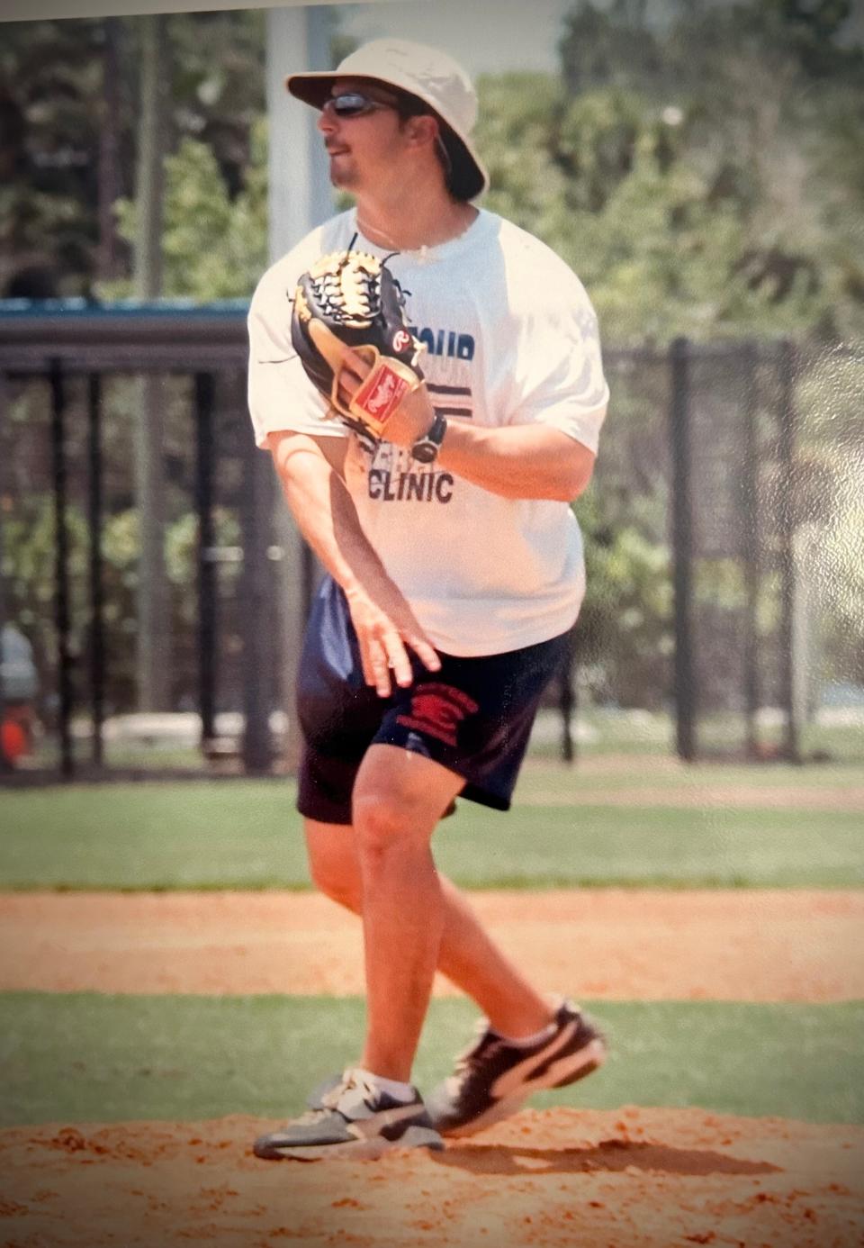 Estero baseball coach Frank Turco throws a pitch in practice.