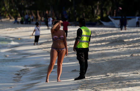 A policeman asks a tourist to leave the beach during the shutdown of the holiday island Boracay, in Philippines April 26, 2018. REUTERS/Erik De Castro