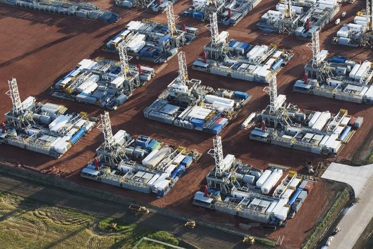 Stacked rigs are seen along with other idled oil drilling equipment at a depot in Dickinson, North Dakota June 26, 2015. REUTERS/Andrew Cullen/Files