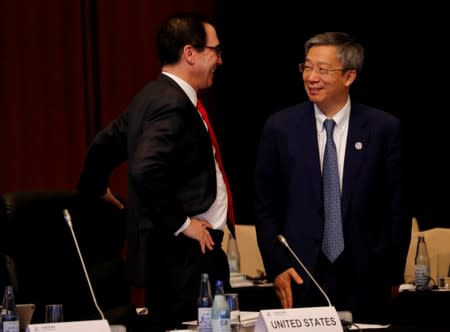 U.S. Treasury Secretary Steven Mnuchin talks with China's Central Bank Governor Yi Gang during the G20 finance ministers and central bank governors meeting in Fukuoka