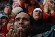 <p>Kashmiri Muslims offer prayers as an unseen clergyman displays a relic at the shrine of Sheikh Abdul Qadir Geelani in Srinagar on January 29, 2016. Devotees are marking the last Friday of Urs (Festival) of the saint who lived in Baghdad some 1,000 years ago and is buried there. Kashmiri Muslims hold the saint in high esteem and have set up scores of shrines and mosques in his memory. </p>