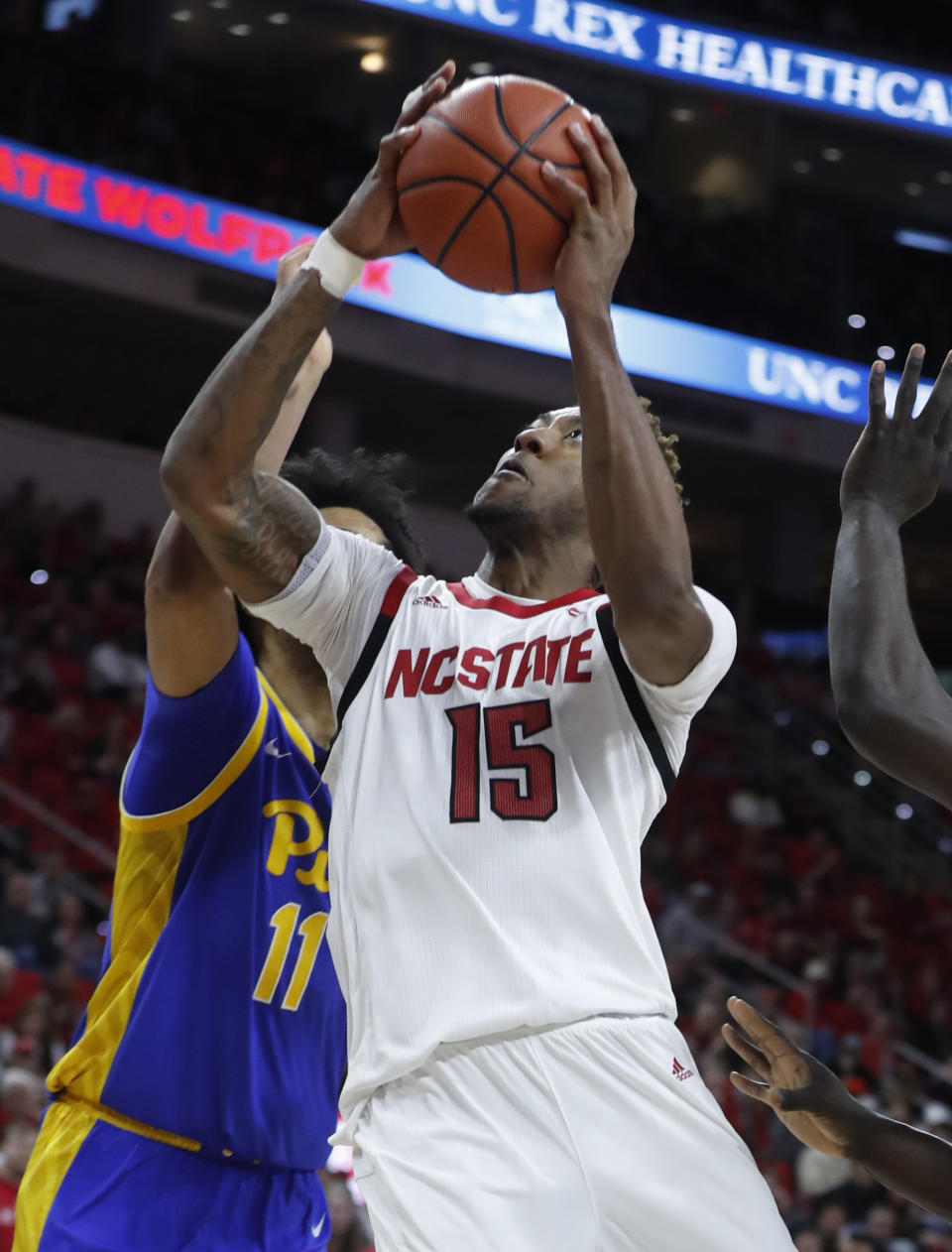 North Carolina State's Manny Bates (15) drives to the basket as Pittsburgh's Justin Champagnie (11) defends during the first half of an NCAA college basketball game at PNC Arena in Raleigh, N.C., Saturday, Feb. 29, 2020. (Ethan Hyman/The News & Observer via AP)