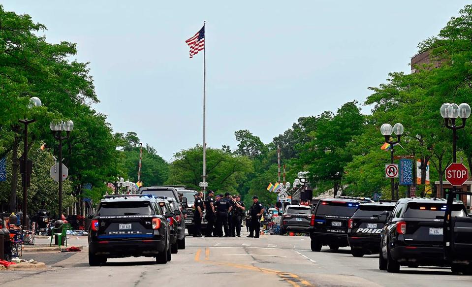 Police from several municipalities search downtown Highland Park, Ill., on July 4 after the mass shooting at a parade.