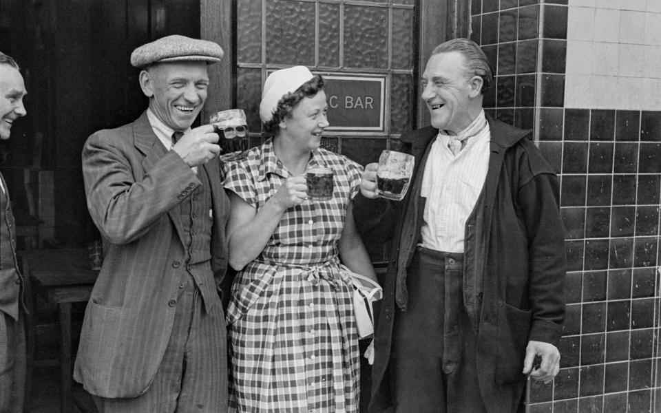 A female journalist having a drink with Tobacco Dock workers, March 1952  - Picture Post/Hulton Archive/Getty Images/Grace Robertson