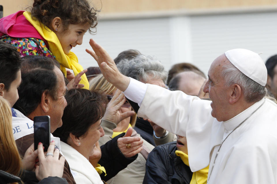 Pope Francis greets faithful as he arrives at the Don Gnocchi Foundation Center to celebrate the rite of the washing of the feet, in Rome, Thursday, April 17, 2014. Pope Francis has washed the feet of 12 elderly and disabled people — women and non-Catholics among them — in a pre-Easter ritual designed to show his willingness to serve like a "slave." Francis' decision in 2013 to perform the Holy Thursday ritual on women and Muslim inmates at a juvenile detention center just two weeks after his election helped define his rule-breaking papacy. It riled traditionalist Catholics, who pointed to the Vatican's own regulations that the ritual be performed only on men since Jesus' 12 apostles were men. The 2014 edition brought Francis to a center for the elderly and disabled Thursday. Francis kneeled down, washed, dried and kissed the feet of a dozen people, some in wheelchairs. He said the ritual is a gesture of "a slave's service." (AP Photo/Riccardo De Luca)