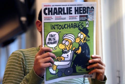 A man reads the back cover of French satirical weekly Charlie Hebdo in Paris. As protests again erupted across the Muslim world on Wednesday over an anti-Islam film, the French magazine poured fuel on the fire by publishing obscene cartoons depicting the Prophet Mohammed