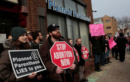 Anti-abortion activists (L) rally next to supporters of Planned Parenthood outside a Planned Parenthood clinic in Detroit, Michigan, U.S. February 11, 2017. REUTERS/Rebecca Cook