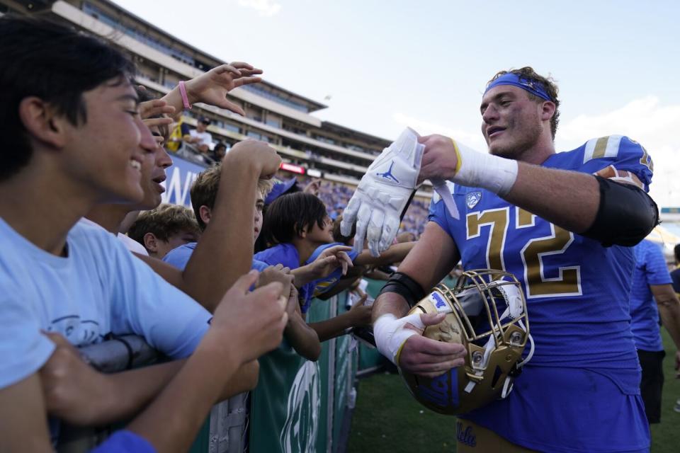 UCLA offensive lineman Garrett DiGiorgio gives his glove to a fan after the Bruins' win over Utah in October.