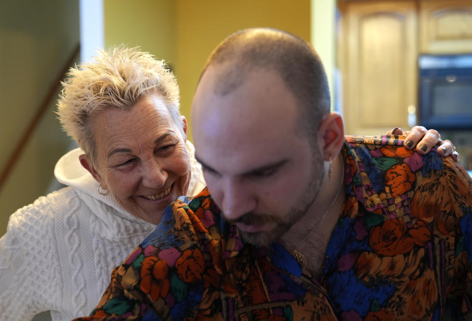 Deb Robertson smiles as she converses with her son Jake before a BBQ with family and friends at her Lombard, Ill., home Saturday, March 23, 2024. She didn’t cry when she learned two months ago that the cancerous tumors in her liver were spreading, portending a tormented death. But later, she cried after receiving a call that a bill moving through the Illinois Legislature to allow certain terminally ill patients to end their own lives with a doctor’s help had made progress. (AP Photo/Charles Rex Arbogast)