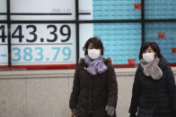 People walk by an electronic stock board of a securities firm in Tokyo, Monday, Jan. 27, 2020. Shares tumbled Monday in the few Asian markets open as China announced sharp increases in the number of people affected in an outbreak of a potentially deadly virus. (AP Photo/Koji Sasahara)