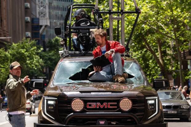 Director David Leitch, who began as a stuntman, speaks with Gosling during a break from filming.