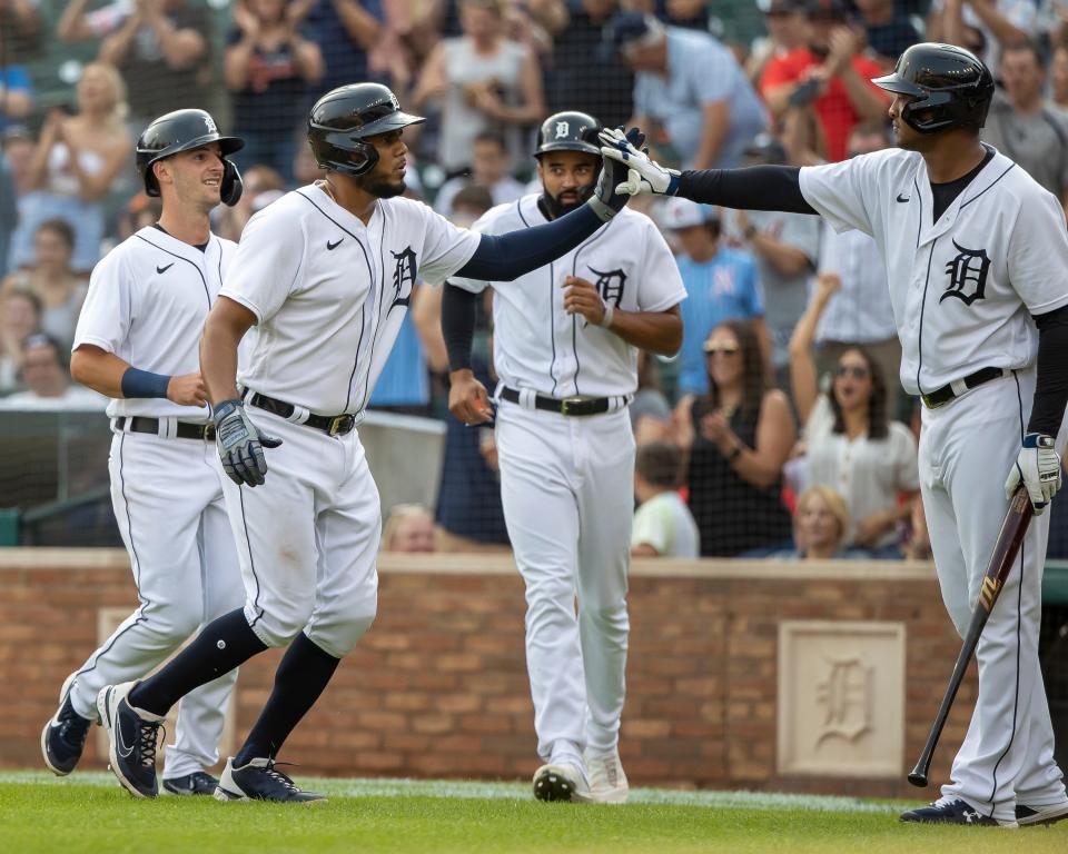 Zack Short, Derek Hill and Jeimer Candelario of the Detroit Tigers high-five teammate Jonathan Schoop after all scoring in the second inning against the Minnesota Twins during game two of a doubleheader at Comerica Park on July 17, 2021, in Detroit.