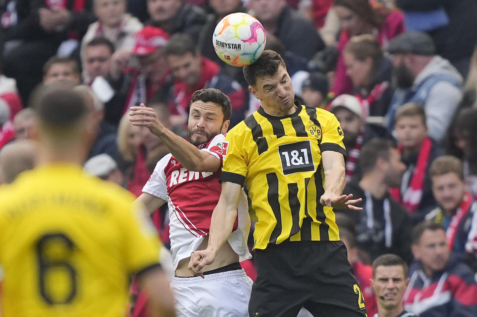 Cologne's Jonas Hector and Dortmund's Thomas Meunier, right, challenge for the ball during the German Bundesliga soccer match between 1.FC Cologne and Borussia Dortmund in Cologne, Germany, Saturday, Oct. 1, 2022. (AP Photo/Martin Meissner)