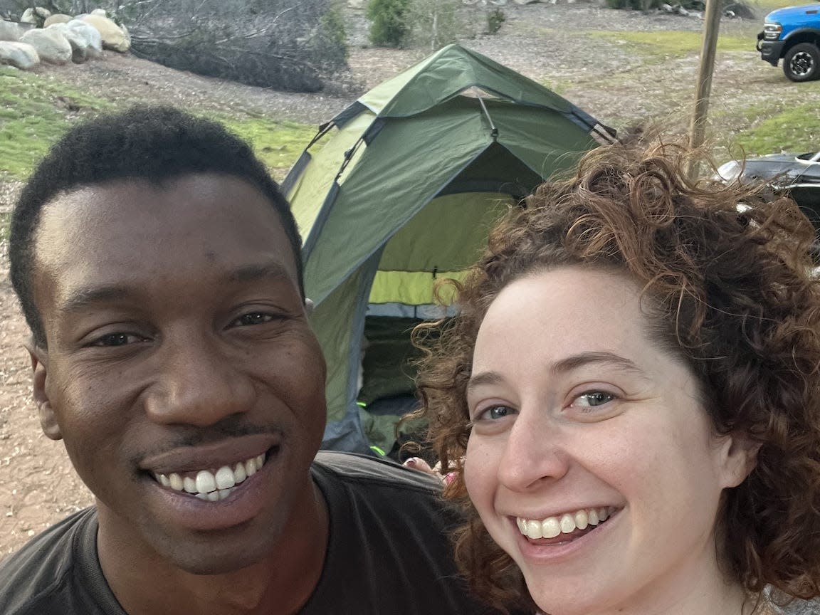 Couple posing in front of a camping tent