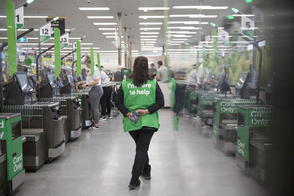 An employee supervises self-service checkout kiosks at a Woolworths Group Ltd. grocery store in Sydney.