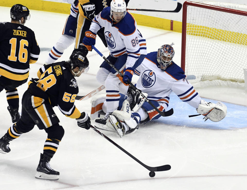 Pittsburgh Penguins defenseman Kris Letang (58) shoots and scores on Edmonton Oilers goalie Stuart Skinner (74) during the first period of an NHL hockey game, Thursday, Feb. 23, 2023, in Pittsburgh. (AP Photo/Philip G. Pavely)