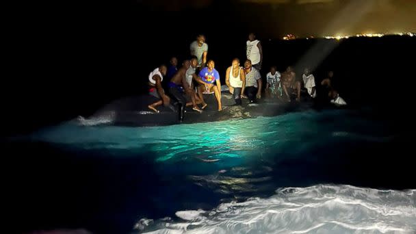 PHOTO: Survivors of a migrant boat that capsized perch on the overturned vessel off the coast of New Providence island, Bahamas, July 24, 2022.  (Royal Bahamas Defence Force via Reuters)