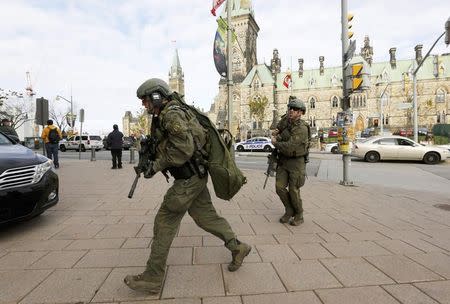 Armed RCMP officers head towards the Langevin Block on Parliament Hilll following a shooting incident in Ottawa October 22, 2014. REUTERS/Chris Wattie