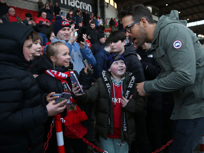 Ryan Reynolds saluda a unos fans en el fútbol