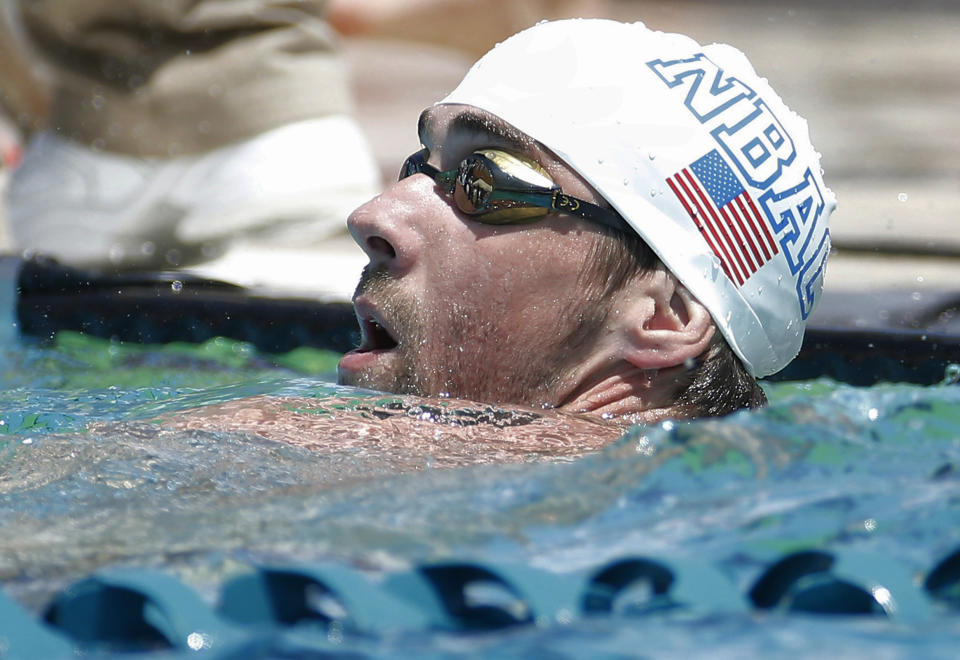 Michael Phelps looks at the scoreboard after the 100-meter butterfly during the Arena Grand Prix swim meet, Thursday, April 24, 2014, in Mesa, Ariz. It is Phelps' first competitive event after a nearly two-year retirement. (AP Photo/Matt York)