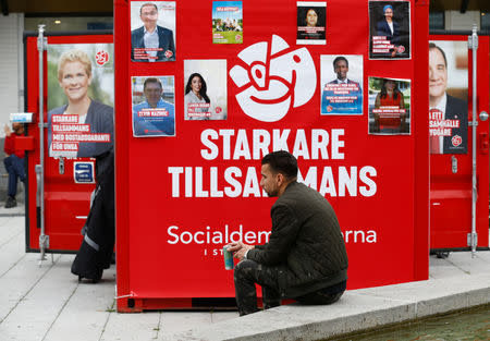 A man sits next to Sweden's Social Democrats party election campaign booth in the Rinkeby neighbourhood in Stockholm, Sweden September 7, 2018. REUTERS/Ints Kalnins