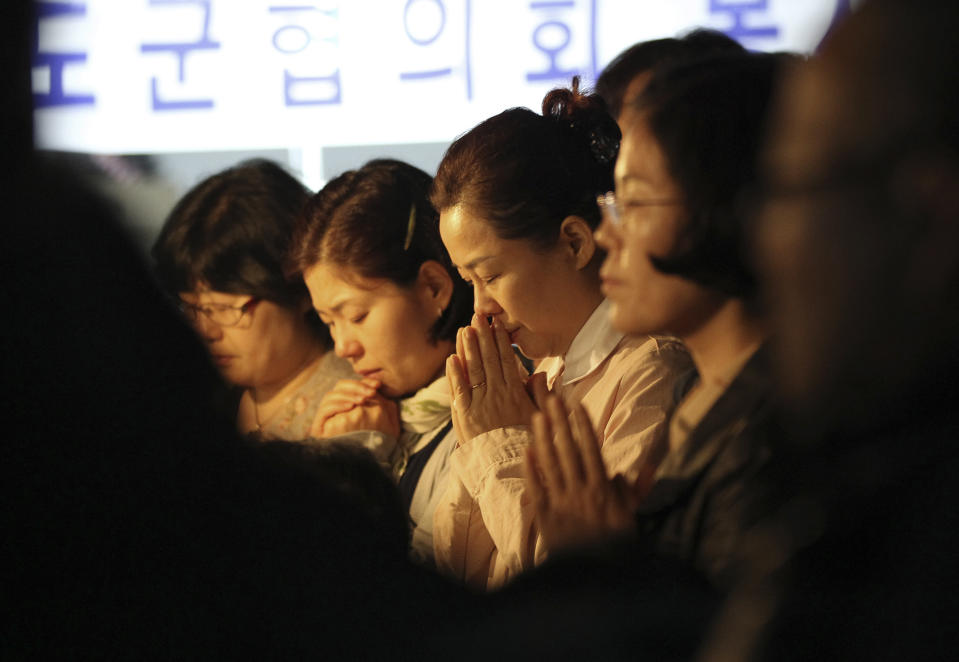 Relatives of missing passengers aboard the sunken ferry Sewol pray to wish for safe return of their family members during an annual Easter service in Jindo, South Korea, Sunday, April 20, 2014. After more than three days of frustration and failure, divers on Sunday finally found a way into the submerged ferry off South Korea's southern shore, discovering more than a dozen bodies inside the ship and pushing the confirmed death toll to over four dozens, officials said. (AP Photo/Ahn Young-joon)