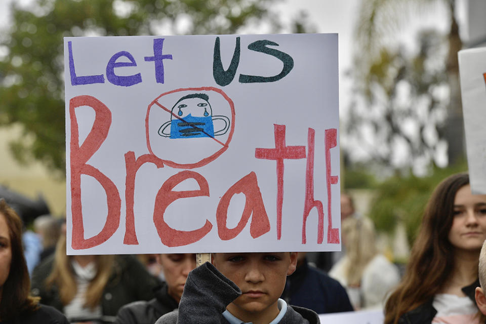 Chase Beamish, 12, listens to a speaker during an anti-mask rally outside the Orange County Department of Education in Costa Mesa, California, on Monday, May 17. More than 200 people came out to protest children in school being forced to wear masks. (Jeff Gritchen / Orange County Register via Getty Images)