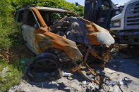 A burned out car sits on the side of the road in Philadelphia, Thursday, July 14, 2022. Officers normally assigned to a unit that deals with livability issues like graffiti, nuisance businesses and abandoned cars have been shifted to the city center and violent hot spots around Philadelphia, where the homicide rate reached a record high last year. (AP Photo/Matt Rourke)