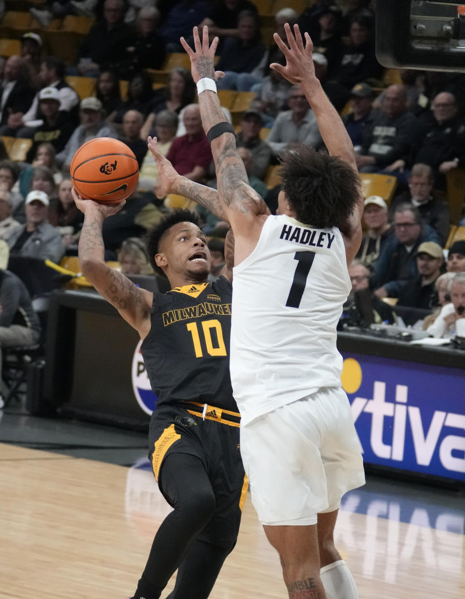 Milwaukee guard BJ Freeman, left, drives the lane to shoot over Colorado guard J'Vonne Hadley during the first half of an NCAA college basketball game Tuesday, Nov. 14, 2023, in Boulder, Colo. (AP Photo/David Zalubowski)