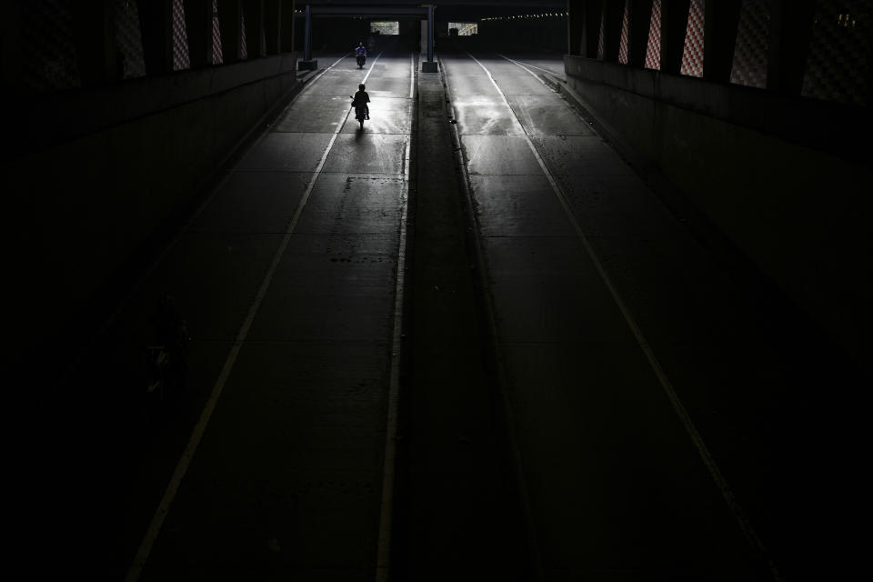 A man drives his motorbike on Bolivar Avenue in Caracas, Venezuela, Saturday, Sept. 10, 2022. (AP Photo/Matias Delacroix)