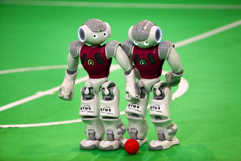 Robots from German Nao-Team HTWK of the Leipzig University of Applied Sciences take part in a football game against 'Dutch Nao Team' from the Van Amsterdam University, during the RoboCup Iran Open 2014, in Tehran, on April 10