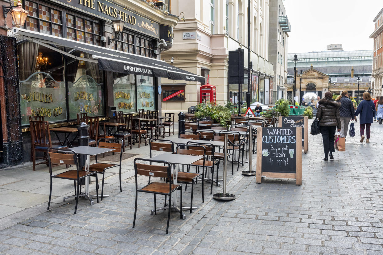 Empty tables are seen outside the The Nags Head pub