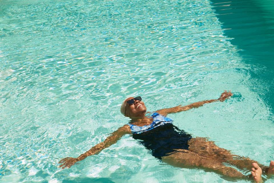 a mature woman relaxes in a swimming pool