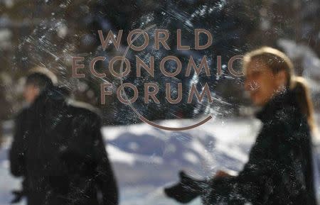 People are pictured through a plastic board as they leave the annual meeting of the World Economic Forum (WEF) in Davos, Switzerland January 23, 2016. REUTERS/Ruben Sprich