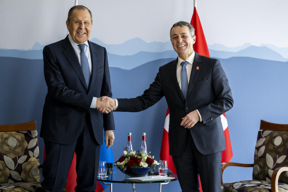 Russian Foreign Minister Sergei Lavrov, left, shake hands with Switzerland's President and head of the Federal Department of Foreign Affairs Ignazio Cassis, right, on the sidelines of the US - Russia foreign ministers meeting in Geneva, Switzerland, Friday, Jan. 21, 2022. (Jean-Christophe Bott/Pool via Keystone)