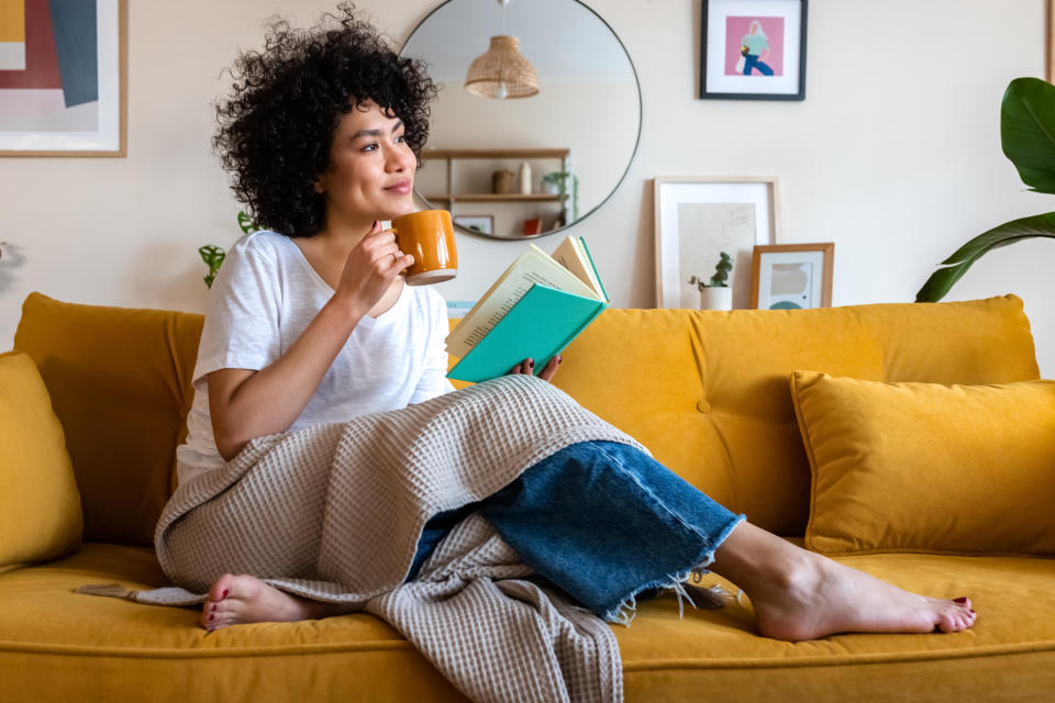 woman relaxing on her couch with a book